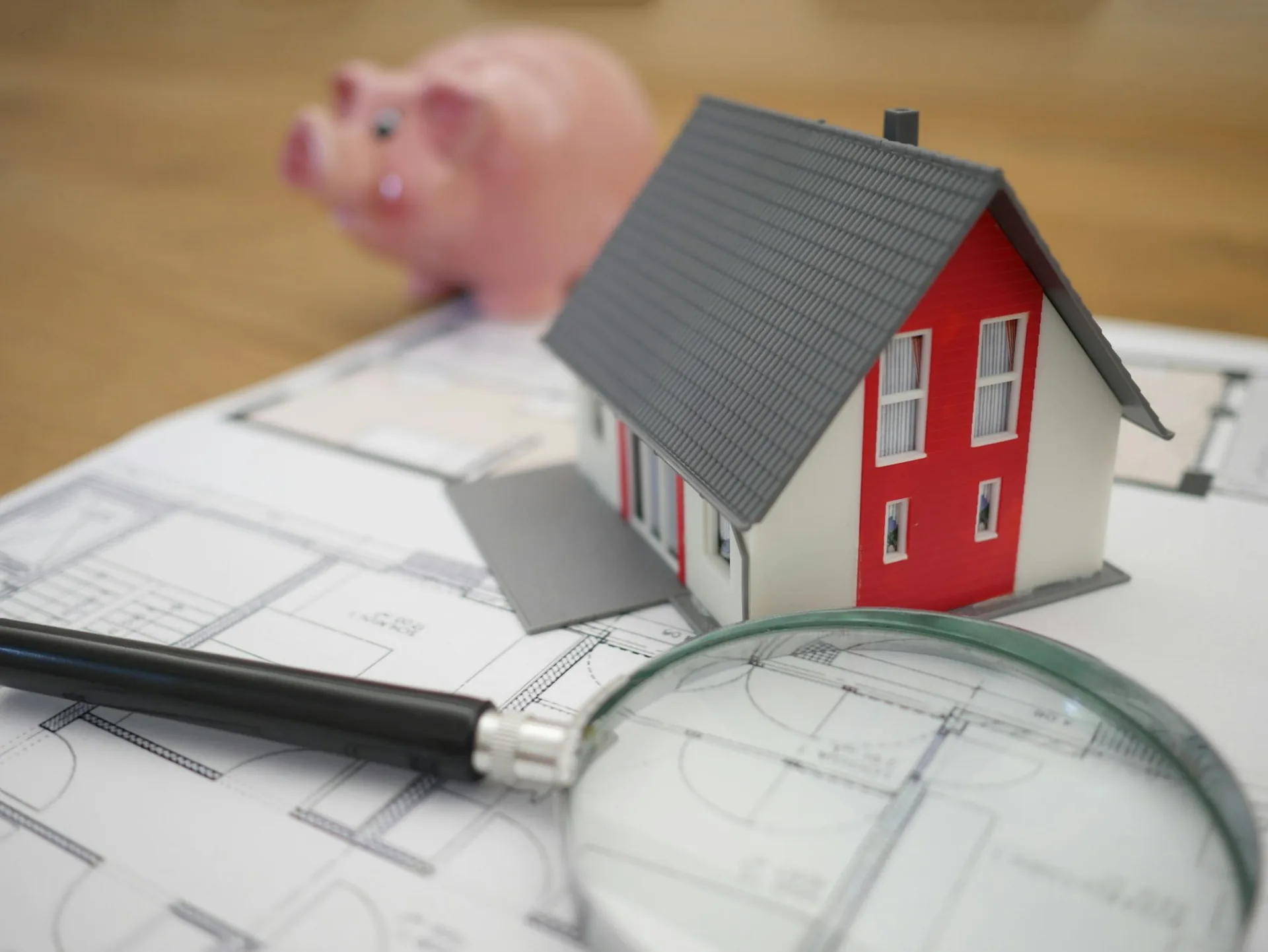 House model and magnifying glass on a set of plans